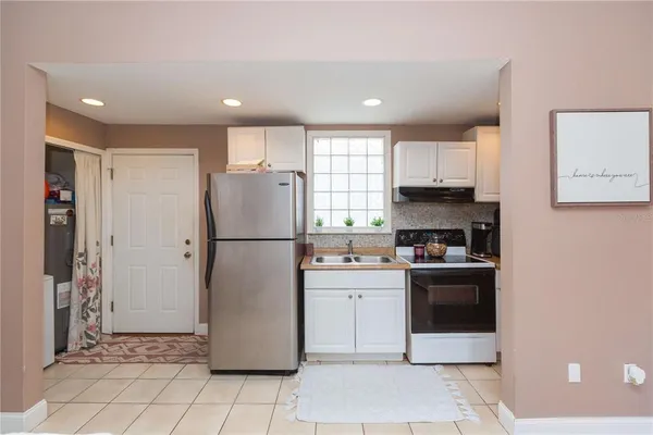 a kitchen with a refrigerator a stove top oven and a sink