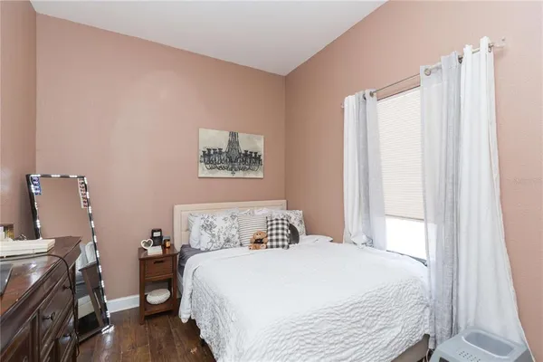 a bedroom with a bed and wooden floor