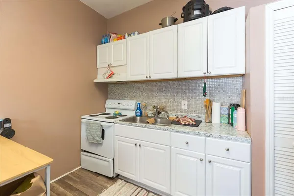 a kitchen with white cabinets and sink