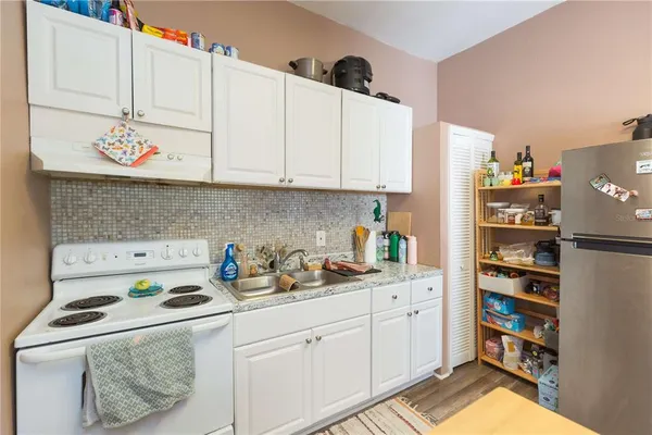 a kitchen with stainless steel appliances a white cabinets and a refrigerator