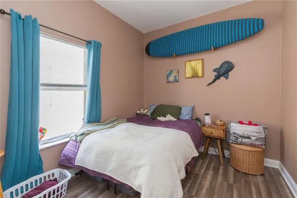 a bedroom with a bed and wooden floor