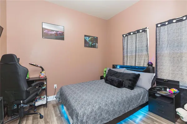 a bedroom with a bed and wooden floor