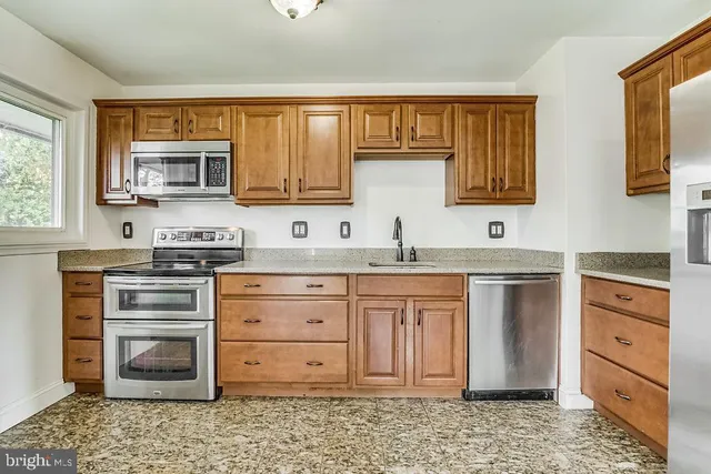 a kitchen with stainless steel appliances granite countertop a stove and cabinets