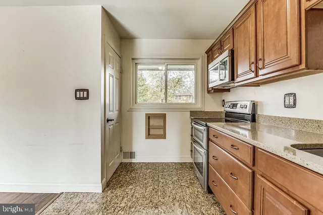 a kitchen with stainless steel appliances granite countertop a refrigerator and a stove top oven