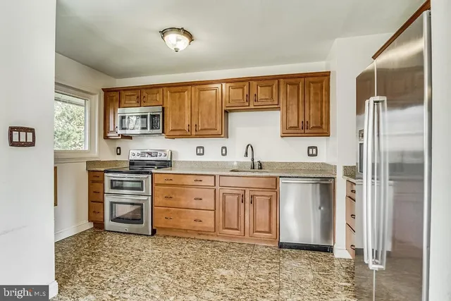 a kitchen with stainless steel appliances granite countertop a refrigerator sink and cabinets