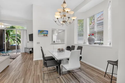 a view of a dining room with furniture a chandelier and wooden floor