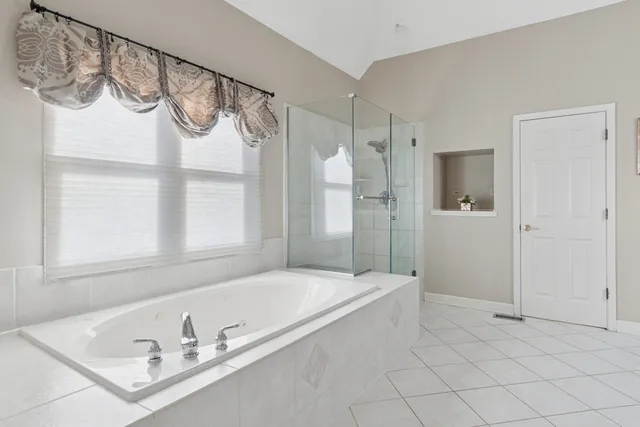 a bathroom with a tub a sink and a shower