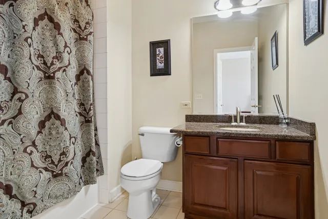 a bathroom with a granite countertop sink and a toilet