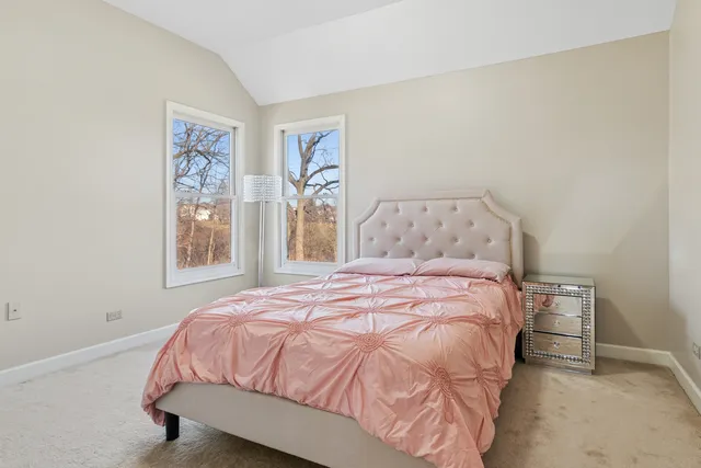 a bedroom with a bed and painting on the wall