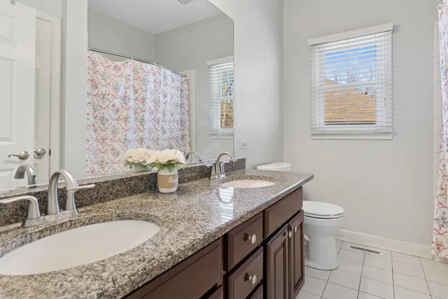 a bathroom with a granite countertop sink a toilet and a mirror