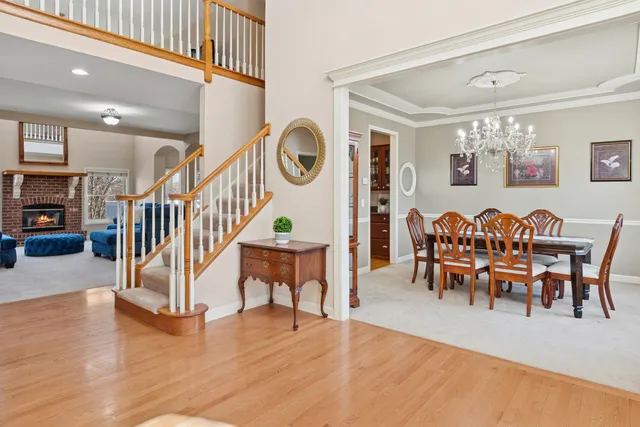 a dining room with furniture a floor to ceiling window and wooden floor
