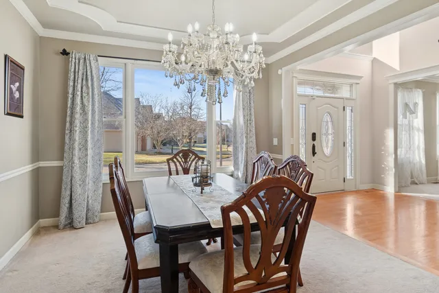 a view of a dining room with furniture a chandelier and wooden floor