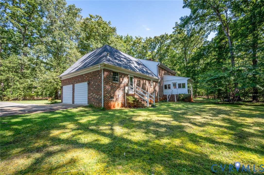 2409 Three Bridge Road Powhatan, VA 23139 - Photo 37 of 39 Brick exterior with a gabled roof and two white ga