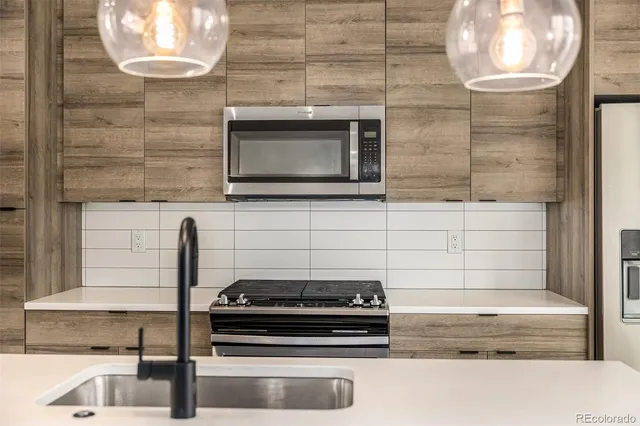 a kitchen with granite countertop a stove and a microwave