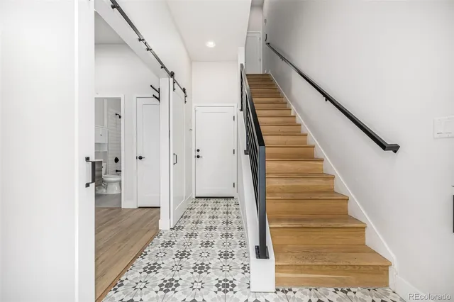 a view of a hallway with wooden floor and entryway