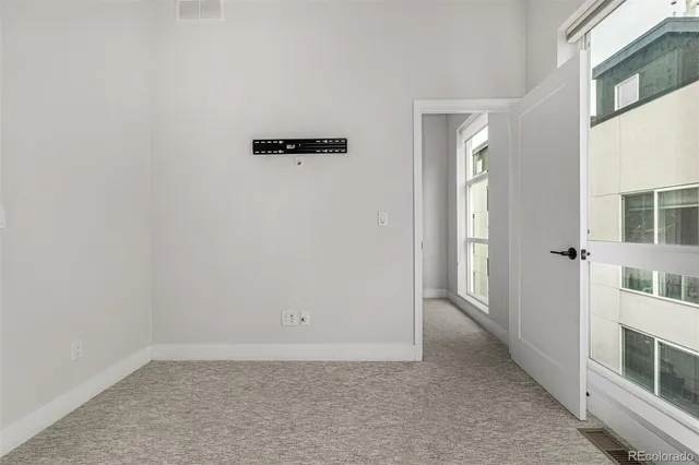 an empty room with cabinet and windows