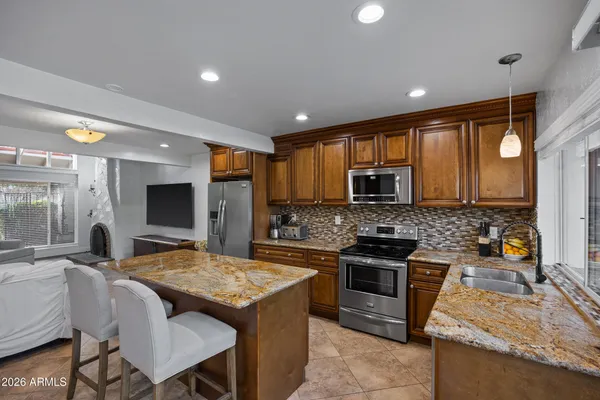 a kitchen with kitchen island stainless steel appliances a sink stove and refrigerator