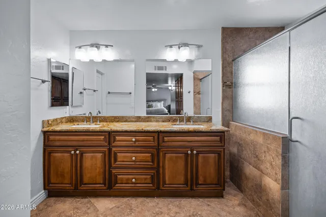 a view of a hallway with wooden floor and a bathroom