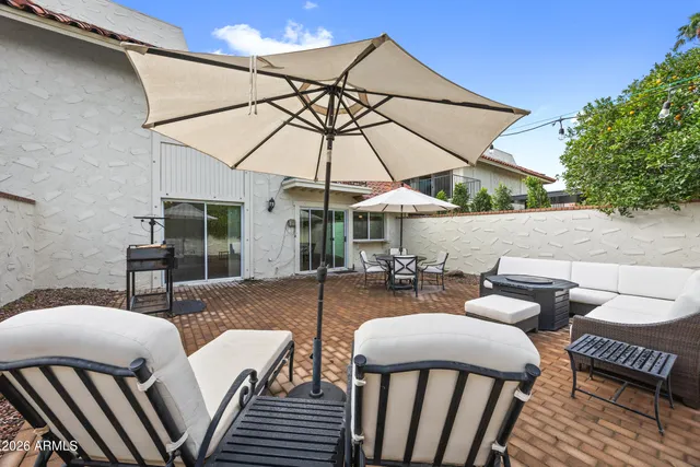 a view of a patio with a table and chairs under an umbrella