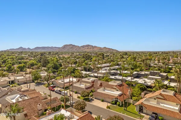 an aerial view of residential houses with outdoor space and trees