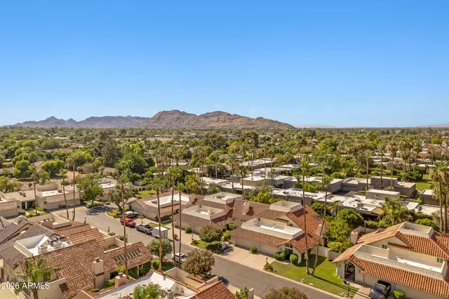 an aerial view of residential houses with outdoor space and trees