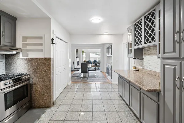 a kitchen with stainless steel appliances granite countertop a stove a sink and a refrigerator