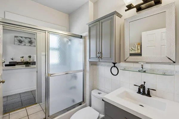 a bathroom with a shower sink vanity and mirror