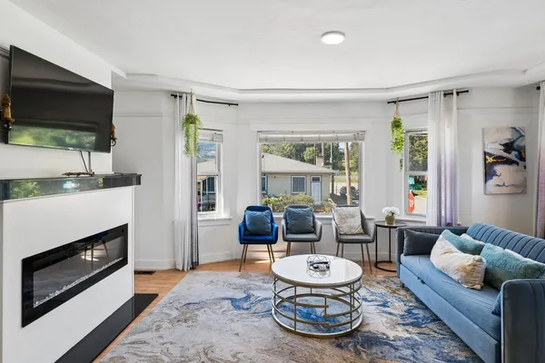 a living room with furniture a flat screen tv and a fireplace