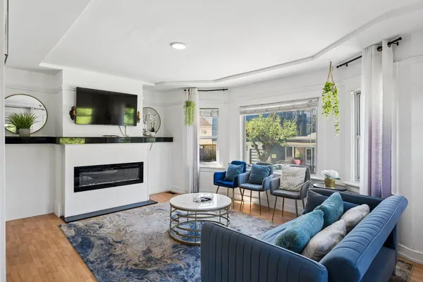 a living room with furniture a flat screen tv and a fireplace