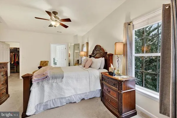 a bedroom with a bed a window and a chandelier
