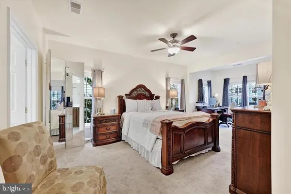 a spacious bedroom with a bed and ceiling fan
