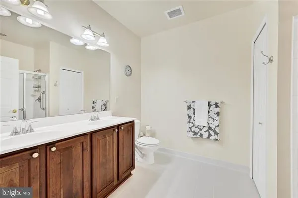 a bathroom with a double vanity sink mirror and toilet