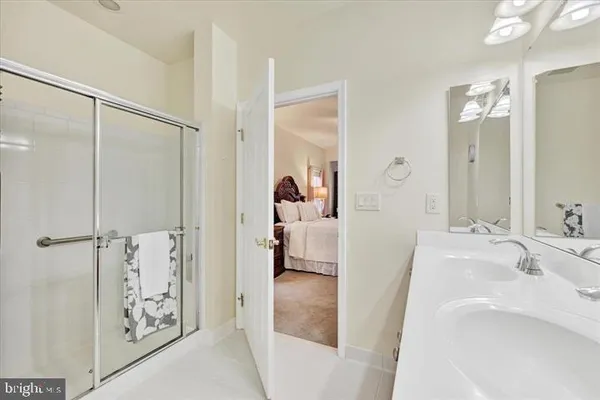 a en suite bathroom with a granite countertop sink mirror and shower
