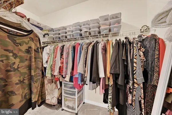 a view of walk in closet with clothes