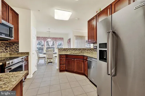 a kitchen with stainless steel appliances granite countertop a refrigerator and a stove top oven