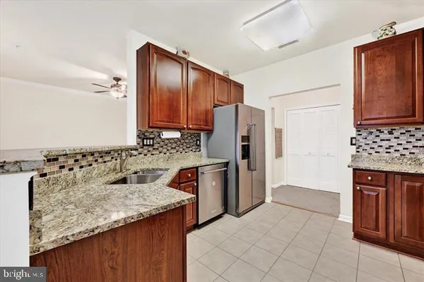 a kitchen with stainless steel appliances granite countertop a refrigerator and a stove top oven