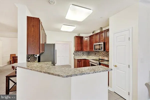 a kitchen with stainless steel appliances granite countertop a sink and a refrigerator