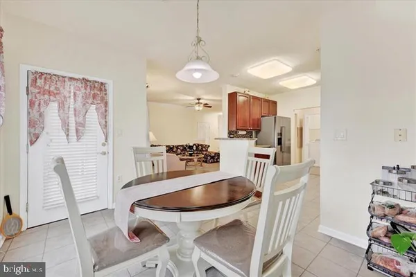 a kitchen with granite countertop a table chairs microwave and cabinets