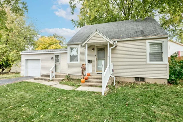 a front view of a house with a yard and outdoor seating