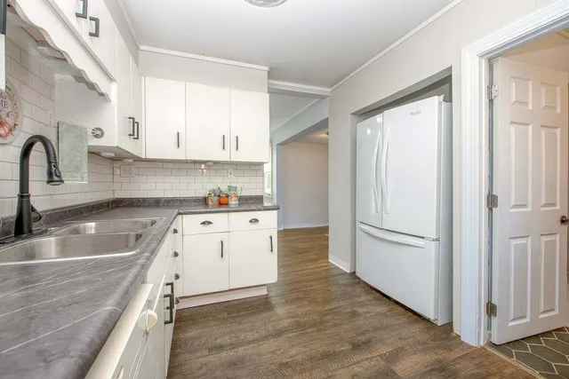 a kitchen with granite countertop a sink stove and refrigerator