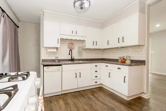 a kitchen with granite countertop white cabinets and white appliances