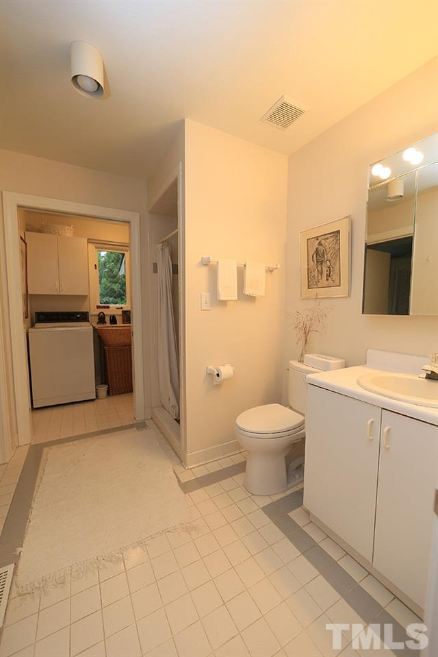 1504 Pecore Place Raleigh, NC 27615 - Photo 19 of 25 1 of 3 full baths that has a door open to a bedroom as well as main hallway.
