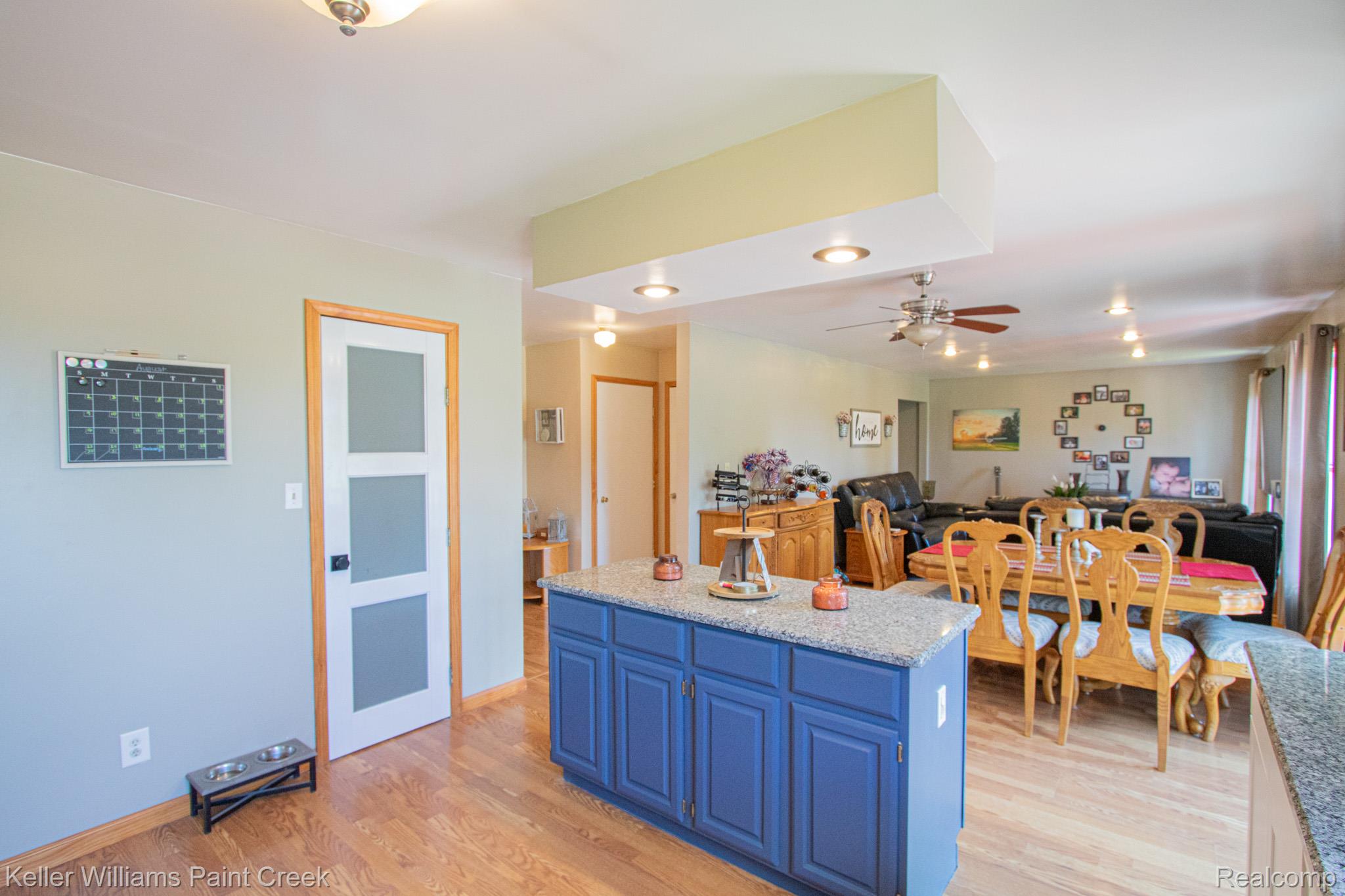 625 Howell Road Allenton, MI 48002 - Photo 10 of 46 Kitchen island with blue cabinetry and a light-toned countertop, wood-finish flooring, and recessed lighting