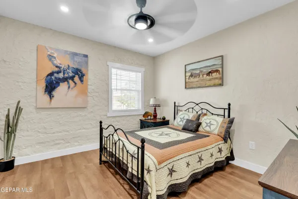 a bedroom with a bed and a painting on the wall