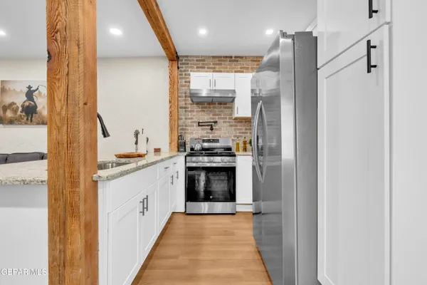 a kitchen with stainless steel appliances granite countertop a refrigerator and a stove