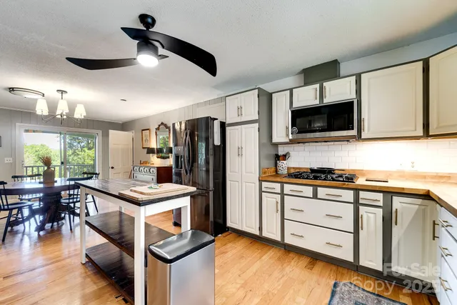 a kitchen with stainless steel appliances kitchen island granite countertop a stove refrigerator and microwave