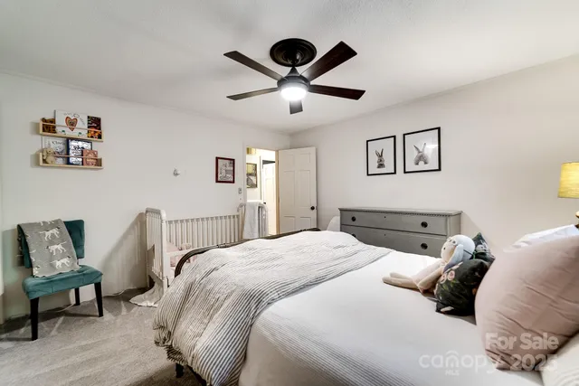 a bed sitting in a spacious bedroom next to a window