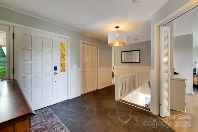 a view of a hallway with wooden floor and cabinet