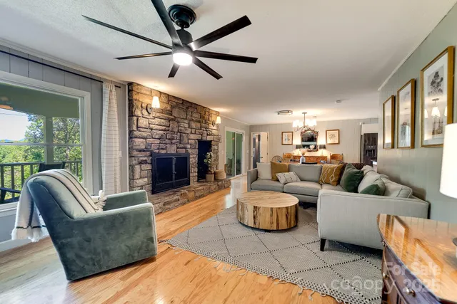 a living room with furniture a fireplace and a large window