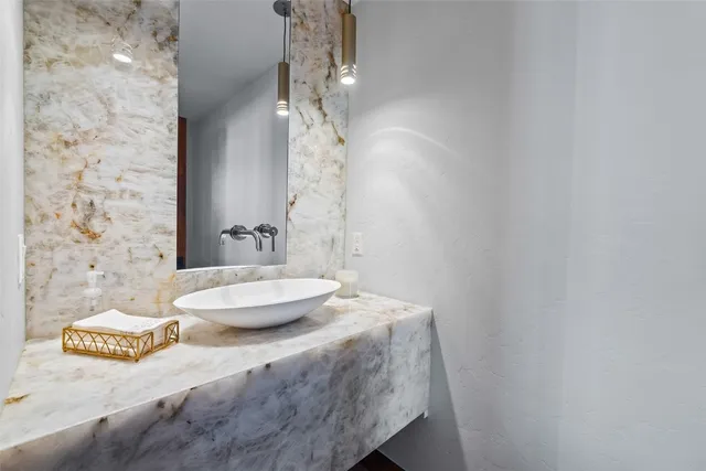 a bathroom with a granite countertop sink a toilet and a mirror